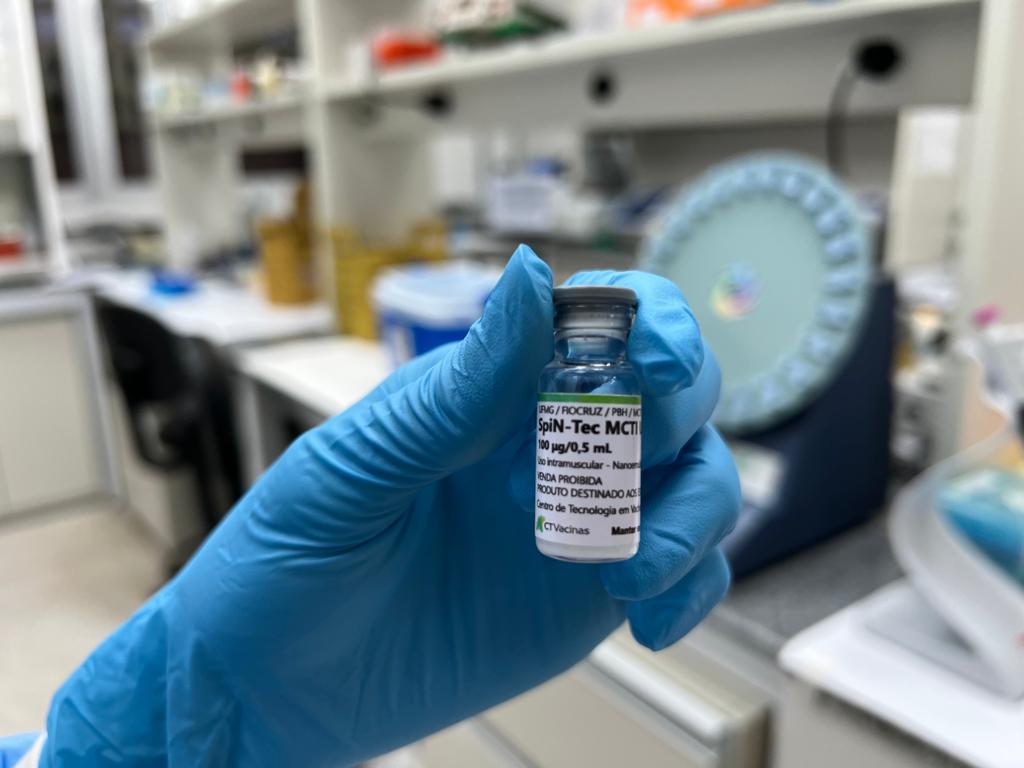 Mão com luva segura frasco da SpiN-TEC em laboratório