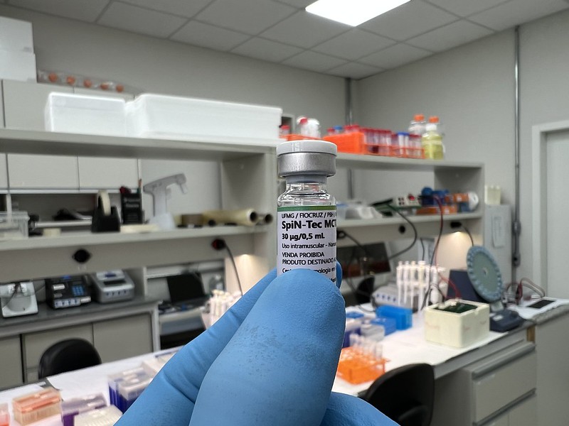 Frasco da SpiN-TEC em primeiro plano e um laboratório do CTVacinas ao fundo