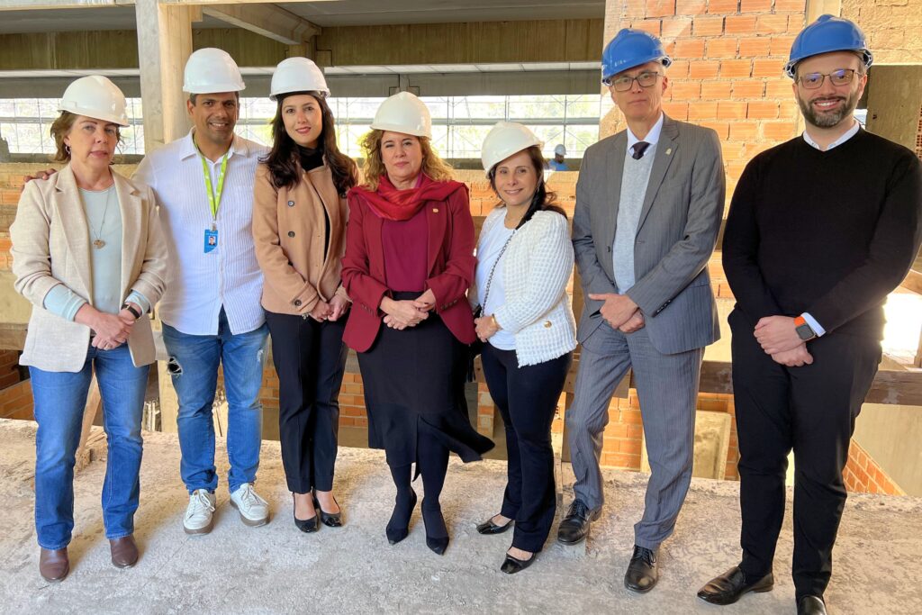 Secretária Mila Corrêa posa para foto nas obras do Centro Nacional de Vacinas com o comitê gestor e a reitora Sandra Goulart, além do subsecretário Lucas Mendes