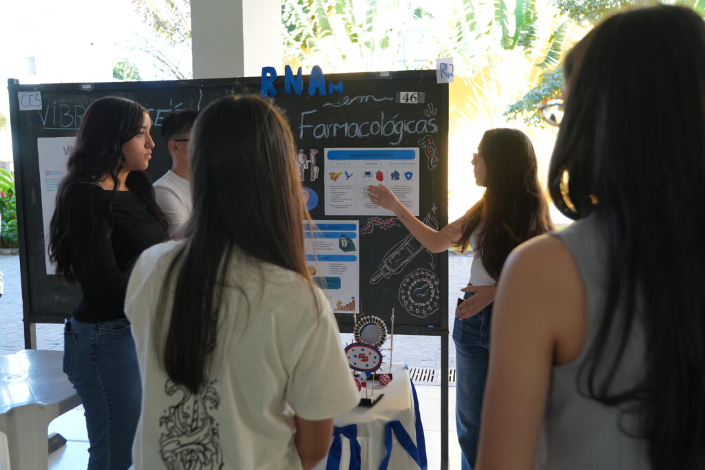 Jovens explicam ciência no estande do CTVACINAS Clubes de Ciência