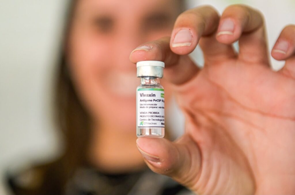 Frasco da vacina Vivaxin sendo segurado pela pesquisadora Ana Clara Gazzinelli